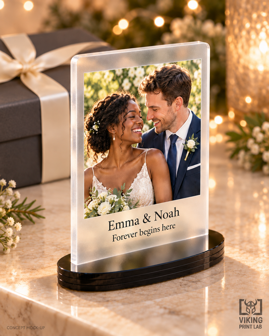 Everheld frosted acrylic wedding photo keepsake beside a wrapped gift and warm festive lights.