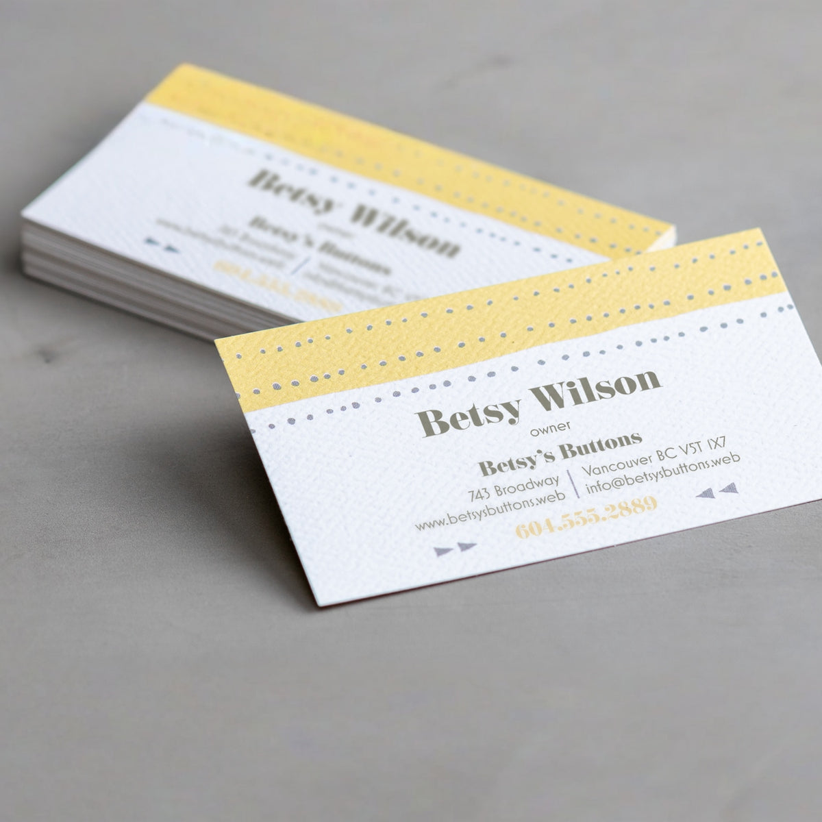 Example natural textured business cards with a yellow and white design.