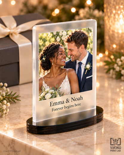 Everheld frosted acrylic wedding photo keepsake beside a wrapped gift and warm festive lights.
