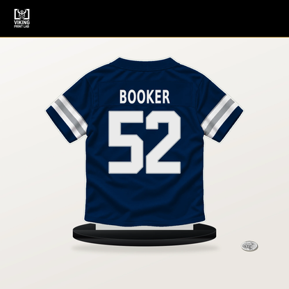 Tyler Booker number 52 Dallas Cowboys jersey stand with included black base.