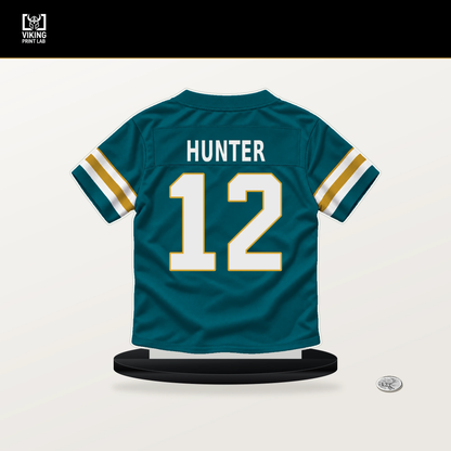Travis Hunter number 12 Jacksonville Jaguars jersey stand with included black base.