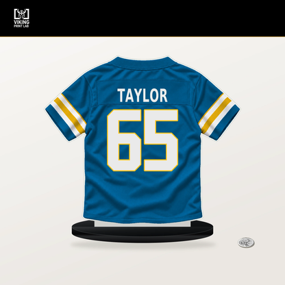 Logan Taylor number 65 Los Angeles Chargers jersey stand with included black base.