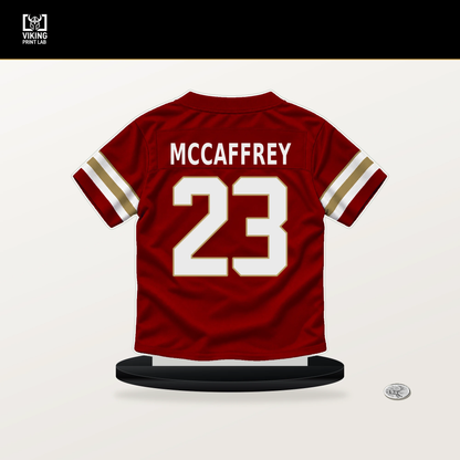 Christian McCaffrey number 23 San Francisco 49ers jersey stand with included black base.