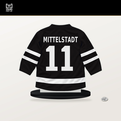 Casey Mittelstadt number 11 Boston Bruins jersey stand with included black base.