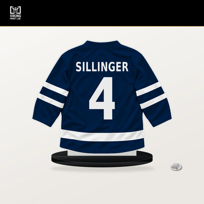 Cole Sillinger number 4 Columbus Blue Jackets jersey stand with included black base.
