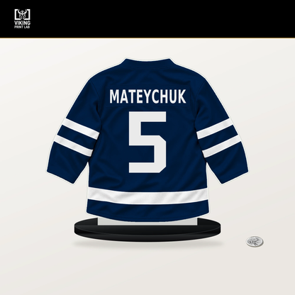 Denton Mateychuk number 5 Columbus Blue Jackets jersey stand with included black base.