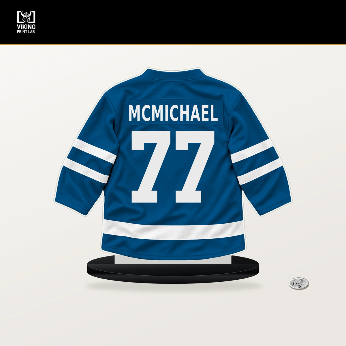 Connor McMichael number 77 St. Louis Blues jersey stand with included black base.