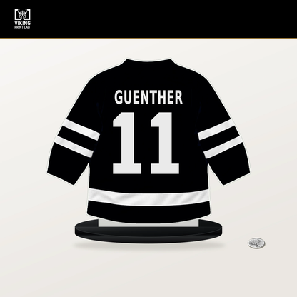 Dylan Guenther number 11 Utah Mammoth jersey stand with included black base.