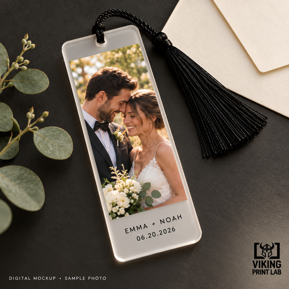 Digital mockup. Frosted wedding photo bookmark personalized with names and a date, displayed on a dark surface.