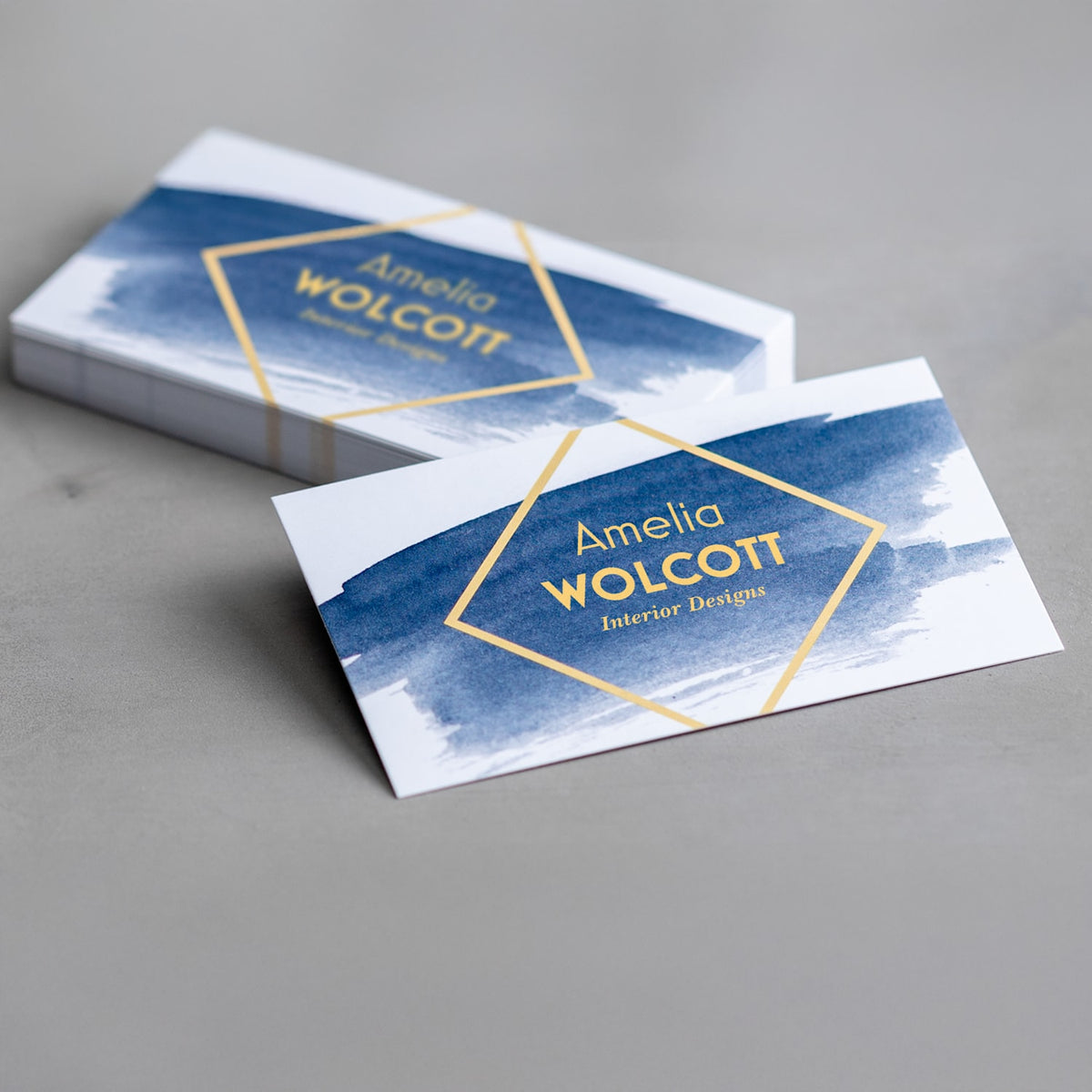 Sample square-corner matte business cards with a blue interior design layout.