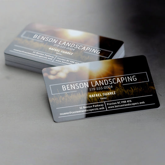 White plastic business card examples with glossy printed landscaping designs.