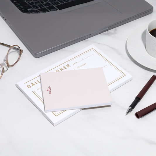 Examples of printed business notepads on a desk.