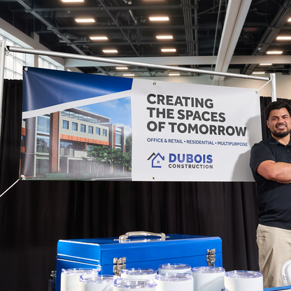 Illustrative custom vinyl banner at a construction trade-show booth