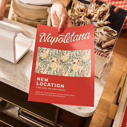 Example full-colour flat restaurant flyer held by hand.