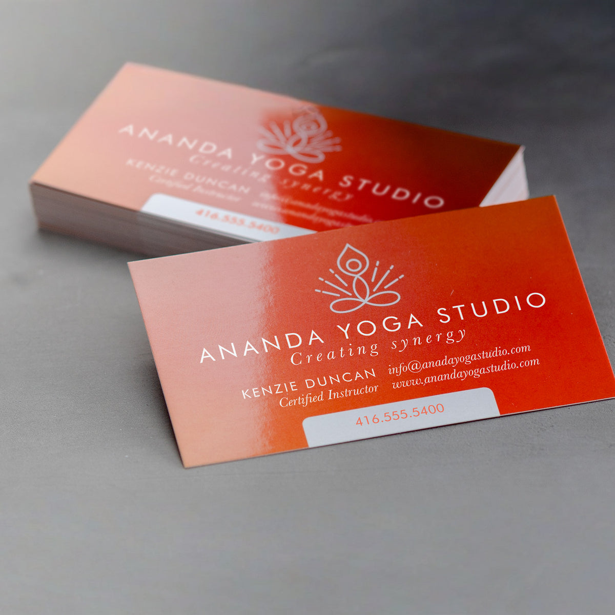Example glossy business cards with a coral yoga studio design.